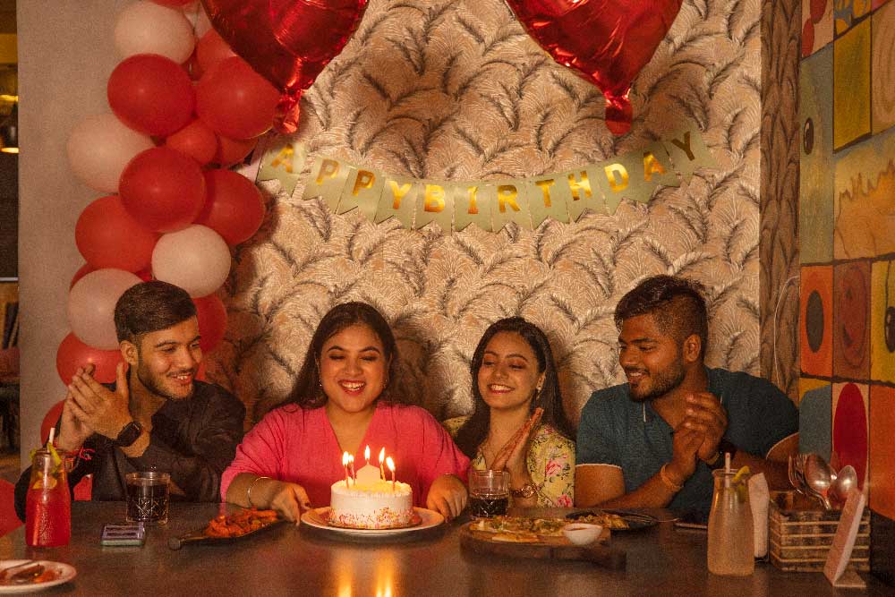 Friends celebrating a birthday with cake and decorations